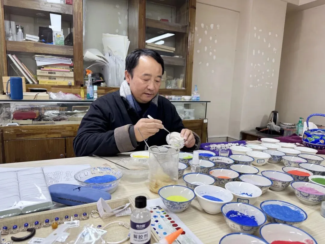 过鹏儒痴迷于永胜银胎珐琅彩技艺十余年。(丽江融媒记者 张小秋 摄)